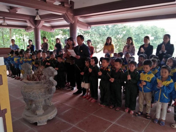 Cô và trẻ đang thắp hương tại nhà bia tưởng niệm các anh hùng liệt sỹ xã nhà.